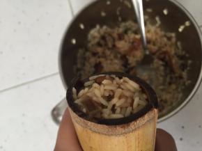 将搅拌好的米料塞入竹筒里