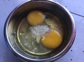 鸡蛋磕入蒸蛋器配的碗中，然后加入盐、鸡精、胡椒粉，然后用打蛋器搅拌均匀