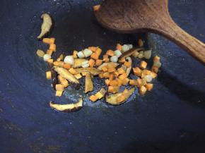 锅里热油后放入香菇、干贝、胡萝卜丁炒香