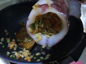 将米饭塞入鱿鱼筒内，要塞得满满当当的，压实点