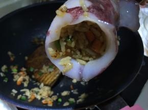 将米饭塞入鱿鱼筒内，要塞得满满当当的，压实点
