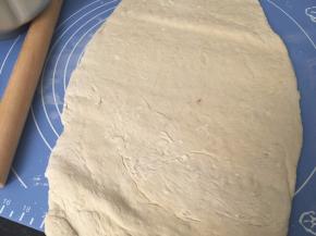 取出后在案板上撒些高筋面粉用擀面杖排气