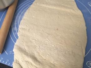 取出后在案板上撒些高筋面粉用擀面杖排气