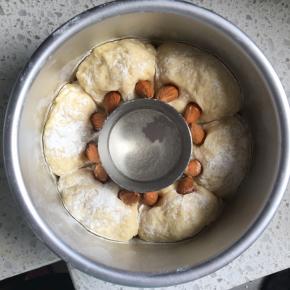 发酵好的面团筛上一层薄薄的高粉，用剪子把面团的里面剪两个小孔，插上巴旦木作为龙猫的耳朵