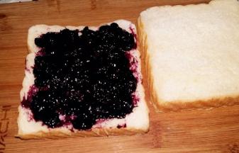 在一片吐司上抹上厚厚的果酱。