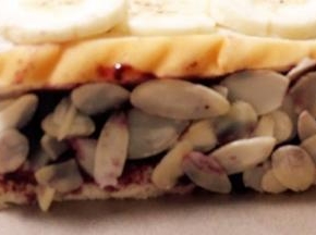 子上倒入适量杏仁片，把吐司四周沾上杏仁片。