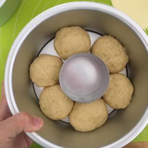 取出发酵好的面团揉出气体，分成均匀的6歌小面团，滚圆，松弛15分钟以后，6寸圆模中间放一个小慕斯圈，把6哥小面团放入，进行第二次发酵，发酵50分钟左右