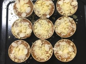 撒上酥粒和杏仁片，没有杏仁片也可以不用，再继续入烤箱烤20分钟，可以插入一根牙签，牙签上没有粘黏面糊即是烤熟了