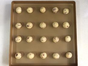 冷藏后取出饼干面团，分成20等份，用双手搓成圆球状，一一摆入烤盘内。