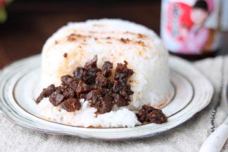 3盛出一碗米饭，浇上麻辣香菇酱。