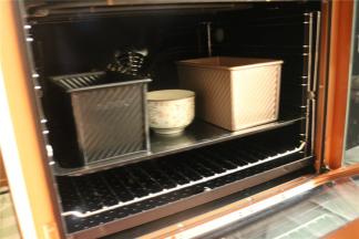 吐司模放入烤箱，再放入一碗热水保持湿度。