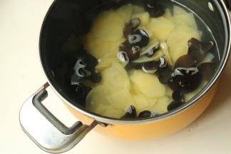 汤锅加水，水开后加入土豆片和木耳煮半分钟。