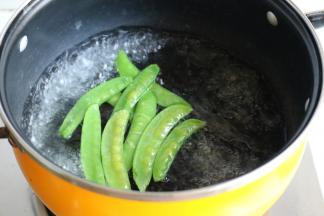 汤锅加水烧开，加少许盐和色拉油，放入荷兰豆，煮半分钟。