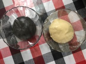 面团切分成2部分，一部分加入可可粉，竹炭粉和水揉均匀，面团收圆分别放入2容器里，包上保鲜膜，室温静置进行一发，约半小时。夏天温度高，我们这里天天30度，具体结合当地室温调整。