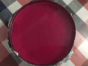 待火龙果的颜色渗到酒冻液里，然后直接倒进之前冷藏好的慕斯表面，然后再放进冰箱冷藏2～3小时后，小心撕掉锡纸，吹风机热风吹一圈慕斯圈或热毛巾敷一下慕斯圈，轻松完美脱模