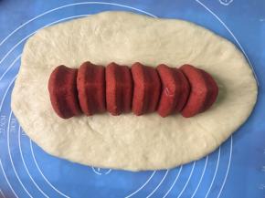 大面团擀开，中间涂上少量蛋液，串好的爱心蛋糕倒着放，捏紧爱心蛋糕上部分凹凸位置，防止出现空洞