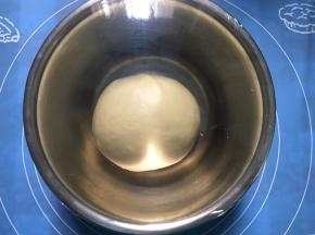 面团收圆放入容器，包上保鲜膜，室温静置进行一发，约1小时。夏天温度高，我们这里天天30度，具体结合当地室温调整。