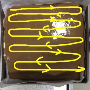 用手指垂直插入蛋糕糊底部中，按图示箭头方向划