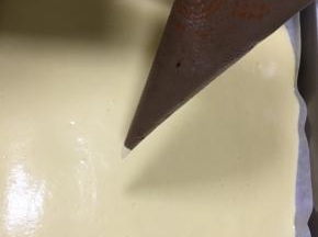 可可蛋糕糊倒入裱花袋内，剪一个小口