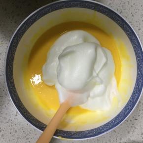 取1/3的蛋白霜到蛋黄糊中，用刮刀翻拌均匀