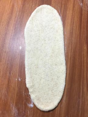 面团擀成椭圆形，按出面团的气泡