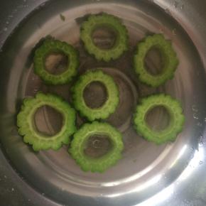 苦瓜开水中焯烫两分钟，水里放少许盐，油，可以让苦瓜保持翠绿。