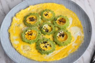 将蛋液倒入锅中，包裹住苦瓜，小火煎熟鸡蛋即可。