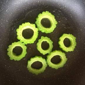 将焯烫好苦瓜放在平底锅内，摆好形状。