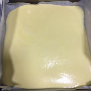 原味蛋糕糊倒入铺了油纸的11寸方形烤盘中，轻轻抹匀开