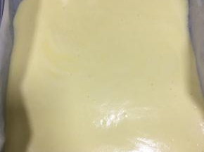 原味蛋糕糊倒入铺了油纸的11寸方形烤盘中，轻轻抹匀开