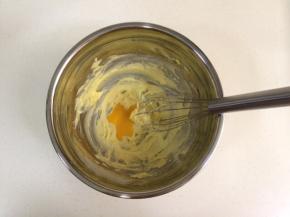 取出蛋黄打散开，分两次加入黄油中，搅拌均匀。