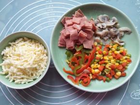 把青椒、红椒、玉米粒豆和蘑菇绰水，培根切小