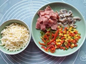 把青椒、红椒、玉米粒豆和蘑菇绰水，培根切小