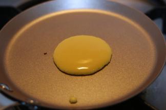 盛一勺面糊，倒进锅中心点的位置，