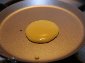 盛一勺面糊，倒进锅中心点的位置，