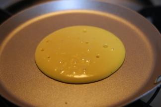 面糊会自动向周边摊开，形成圆形○，待表面冒出许多小孔且暂停时，将其翻面。