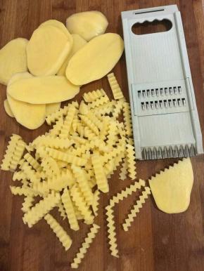 土豆先用刀切成厚薄一致的厚片，再用多功能切菜器下面的波浪形的刀切成条状！（没有多功能切菜器的也可以直接用刀切成条状！）
