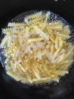 锅中倒入适量的油烧至八成热的时候，放进沥干水分的土豆条炸！

