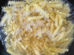 锅中倒入适量的油烧至八成热的时候，放进沥干水分的土豆条炸！

