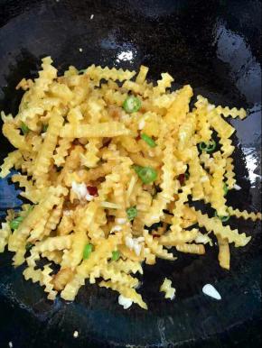 放入炸好的土豆条，加入少许盐翻炒均匀！

