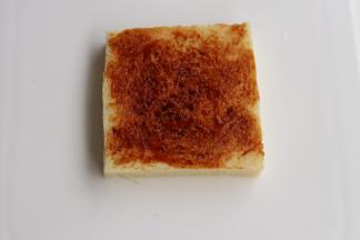 在两片土司片上摸上辣椒酱.