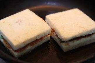 .放上三明治,用锅产等重物压在上方,使其能更好煎入味.3分钟左右翻面,再次煎另一面即可.