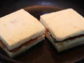 .放上三明治,用锅产等重物压在上方,使其能更好煎入味.3分钟左右翻面,再次煎另一面即可.