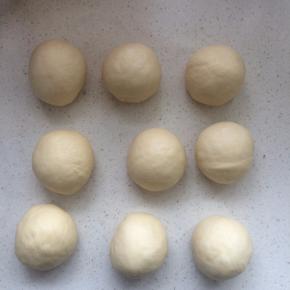 倒出面团，用手掌排气后称重，平均分割为9份，每份约60克，滚圆，加盖保鲜膜静置15分钟