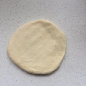 用擀面杖把小面团擀成圆片，排出气泡