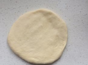 用擀面杖把小面团擀成圆片，排出气泡