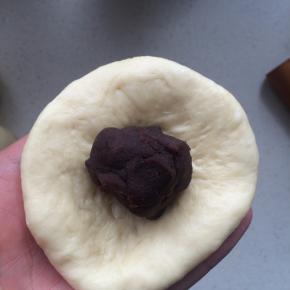 将擀好的面皮翻面，包入豆沙馅