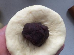 将擀好的面皮翻面，包入豆沙馅