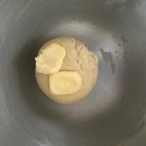 面团揉到光滑后加入软化的黄油，继续中速揉面团
