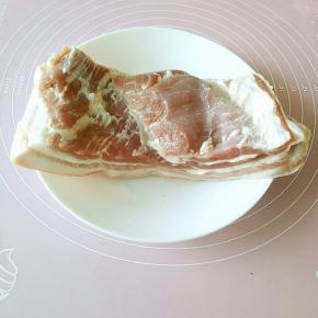 首先选择一块五花三层的带皮猪肉，洗净之后剔去多余的筋膜